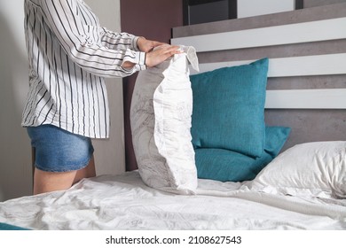 Young Woman Making Bed At Home.