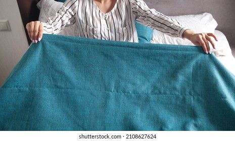 Young Woman Making Bed At Home.