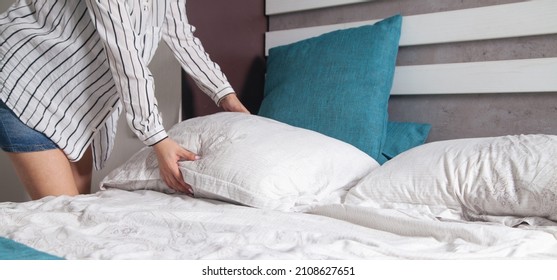 Young Woman Making Bed At Home.