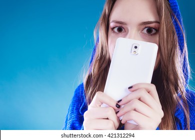 Young Woman Making Big Eyes. Hiding Behind Phone. Pretty Girl In Sweater.