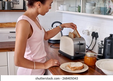 Young Woman Making Breakfast Toast Bread With Toaster At Home Kitchen