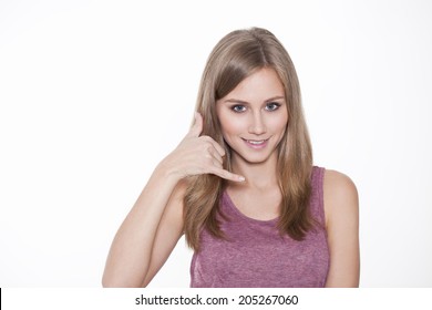 Young Woman Making A Call Me Sign Outdoors 