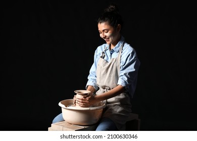 Young Woman Making Ceramic Pot On Dark Background