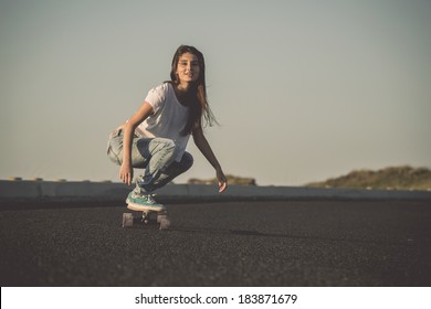 Young Woman Making Downhill With A Skateboard