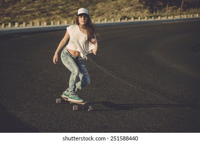 Young Woman Making Downhill With A Skateboard