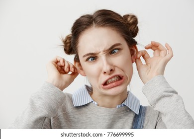 Young Woman Making Goofy Face Being Naughty Prankster With Twisted Mouth. Grimacing Female Actress In Casual Clothes Fooling Around Squinting Eyes On Camera. Close Up