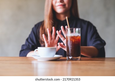 A Young Woman Making Hand Sign To Refuse Iced Coffee And Hot Coffee