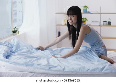 Young Woman Making Her Bed