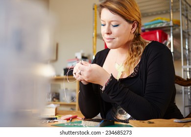 Young Woman Making Jewelry At Home