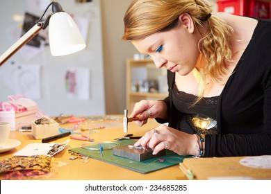 Young Woman Making Jewelry At Home