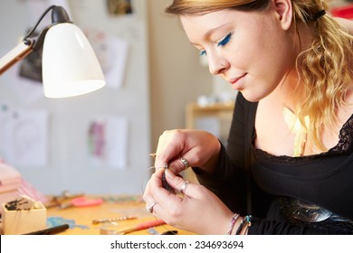 Young Woman Making Jewelry At Home