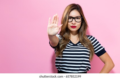 Young Woman Making A Rejection Pose On A Pink Background