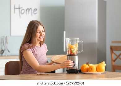 Young woman making smoothie in kitchen at home - Powered by Shutterstock