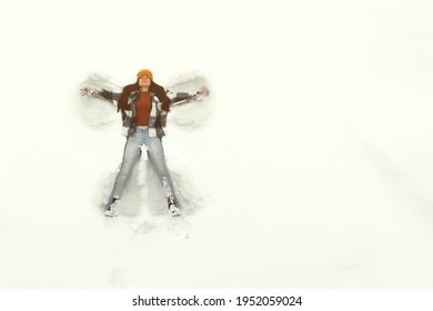 Young Woman Making Snow Angel, Aerial View