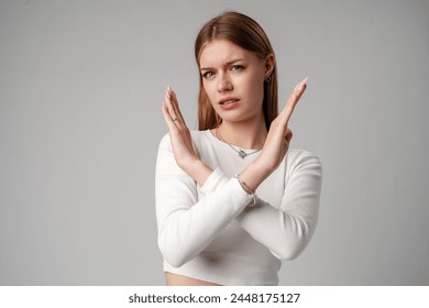 Young Woman Making Stop Gesture Against Grey Background. - Powered by Shutterstock