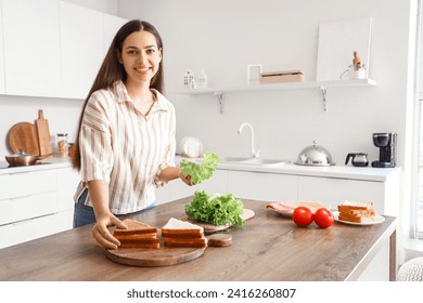 Young woman making tasty sandwich in kitchen - Powered by Shutterstock