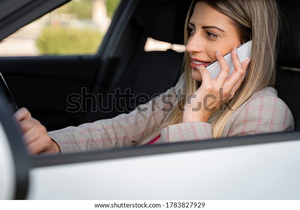 Young woman making traffic violation talking on\
phone while driving