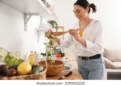 Young woman making vegetable salad in kitchen - Powered by Shutterstock