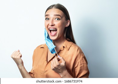 Young Woman Making Winner Gesture Taking Off The Surgeon Mask Smiling Isolated Over White Background