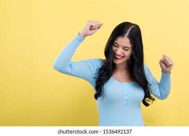 Young Woman Making A Yay Gesture On A Gray Background