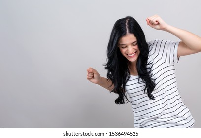 Young Woman Making A Yay Gesture On A Gray Background