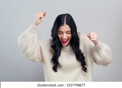 Young Woman Making A Yay Gesture On A Gray Background