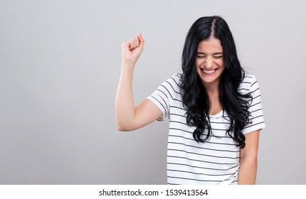 Young Woman Making A Yay Gesture On A Gray Background