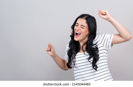 Young Woman Making A Yay Gesture On A Gray Background