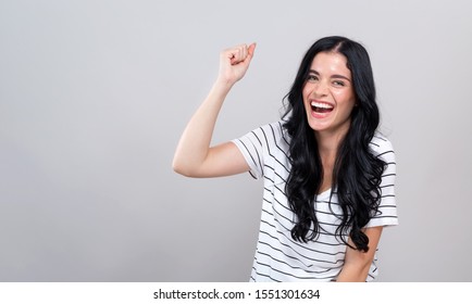 Young Woman Making A Yay Gesture On A Gray Background