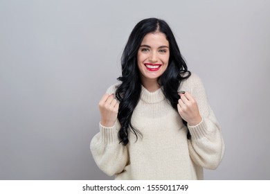 Young Woman Making A Yay Gesture On A Gray Background