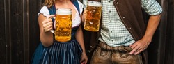 Young Woman And Man With Beer Glass And Pretzel On Wooden Background .Oktoberfest Concept