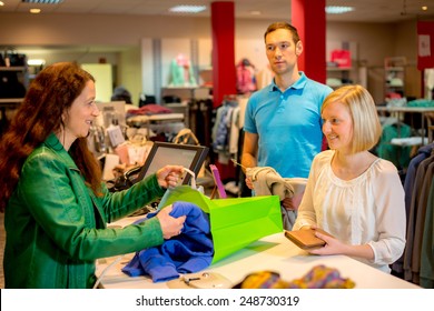 Young Woman And Man In The Clothes Shop Over The Counter