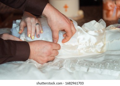 Young Woman And Man Dressing A Baby.