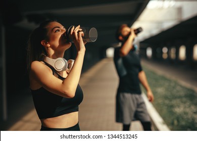 Young Woman And Man Drinking Protein Shake After Workout