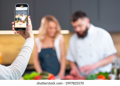 Young Woman And Man Prepare Food And Host A Cooking Show. The Bloggers Stream From Modern Kitchen. Healthy Food Preparation.