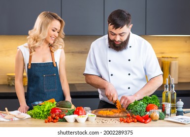 Young Woman And Man Prepare Food And Host A Cooking Show. The Bloggers Stream From Modern Kitchen. Healthy Food Preparation.