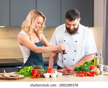 Young Woman And Man Prepare Food And Host A Cooking Show. The Bloggers Stream From Modern Kitchen. Healthy Food Preparation.