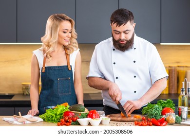 Young Woman And Man Prepare Food And Host A Cooking Show. The Bloggers Stream From Modern Kitchen. Healthy Food Preparation.