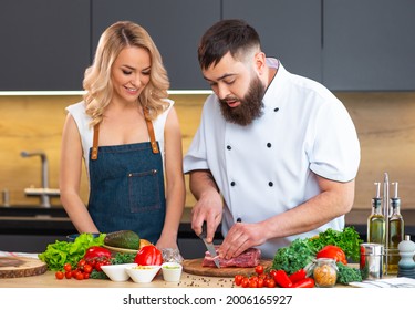 Young Woman And Man Prepare Food And Host A Cooking Show. The Bloggers Stream From Modern Kitchen. Healthy Food Preparation.