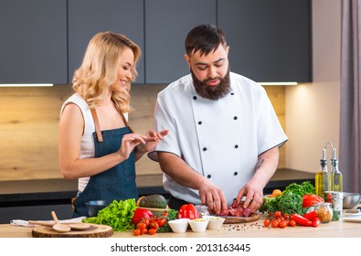 Young Woman And Man Prepare Food And Host A Cooking Show. The Bloggers Stream From Modern Kitchen. Healthy Food Preparation.