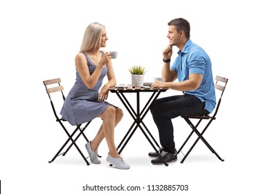 Young woman and a young man seated at a coffee table isolated on white background