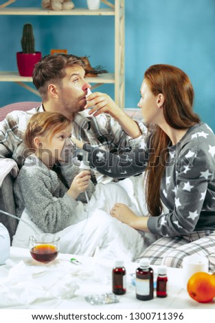 The young woman and man with sick daughter at home. Home Treatment. Fighting with a desease. Medical healthcare. Family iIlness. The winter, influenza, health, pain, parenthood, relationship concept