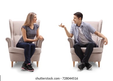 Young woman and a young man sitting in armchairs and talking isolated on white background