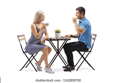 Young Woman And A Young Man Sitting At A Coffee Table Isolated On White Background