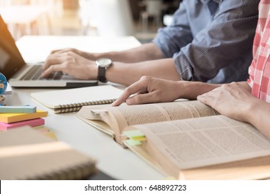 Young Woman And Man Studying For A Test/ An Exam. Tutor Books With Friends. Young Students Campus Helps Friend Catching Up And Learning. People, Learning, Education And School Concept