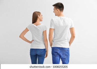Young woman and man in t-shirts on white background. Mockup for design