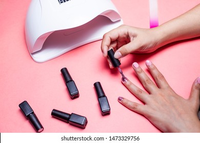 A Young Woman At Manicure Procedure. Woman Nail Polish Process. Female Using Shellac Uv Led Lamp.