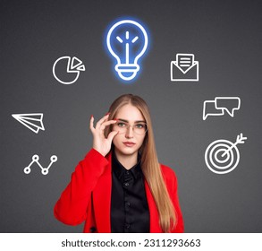 Young woman with many icons and glowing bulb over head. Over gray background. - Shutterstock ID 2311293663