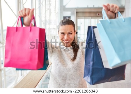Young woman with many shopping bags in the mall as a concept of consumption and purchasing power Foto stock © 