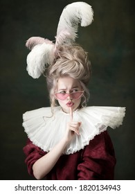 Young woman as Marie Antoinette isolated on dark green background. Retro style, comparison of eras concept. Beautiful female model like classic historical character, old-fashioned.
